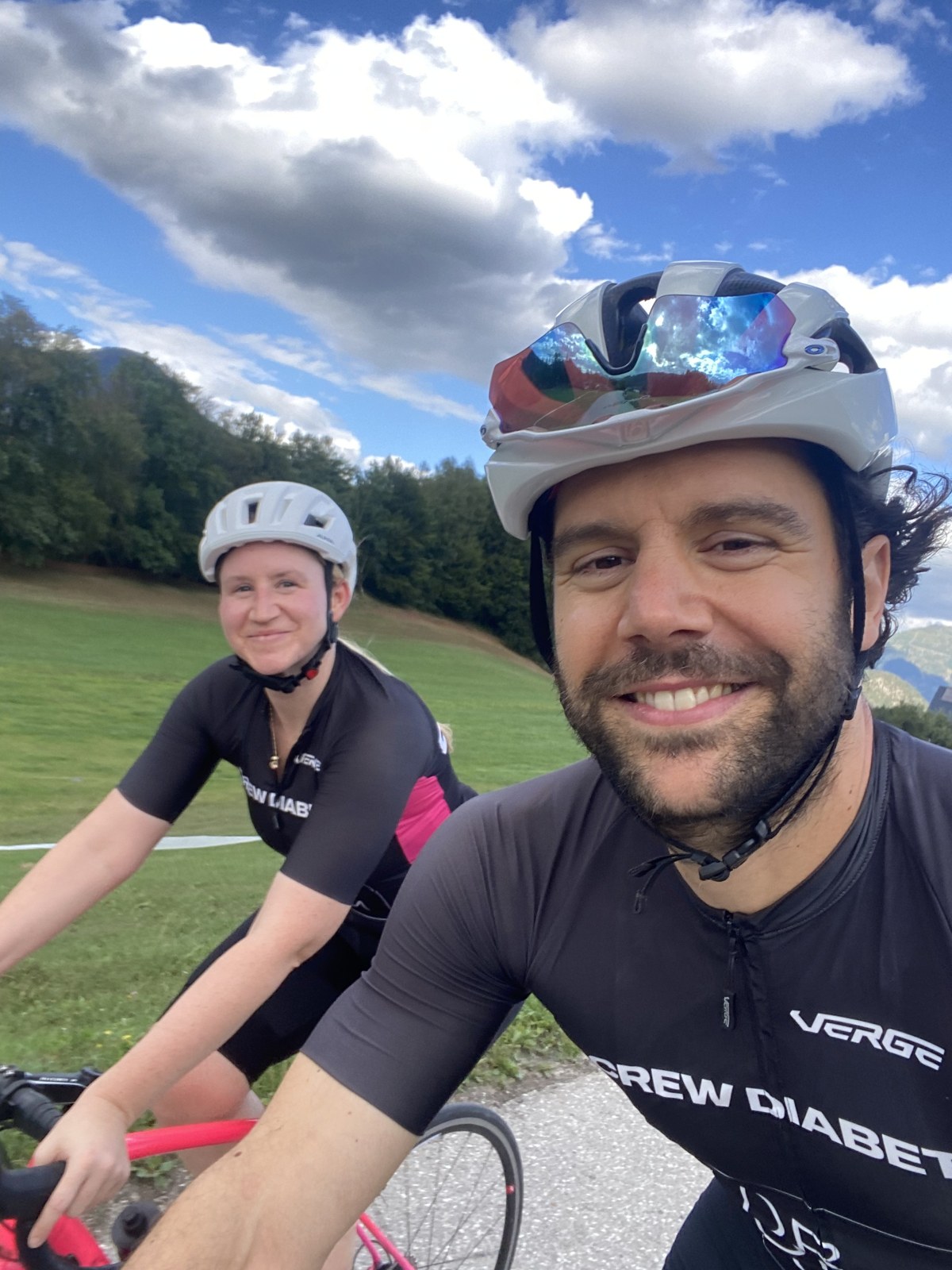 Pedro Dias smiling beside another cyclist on a country road