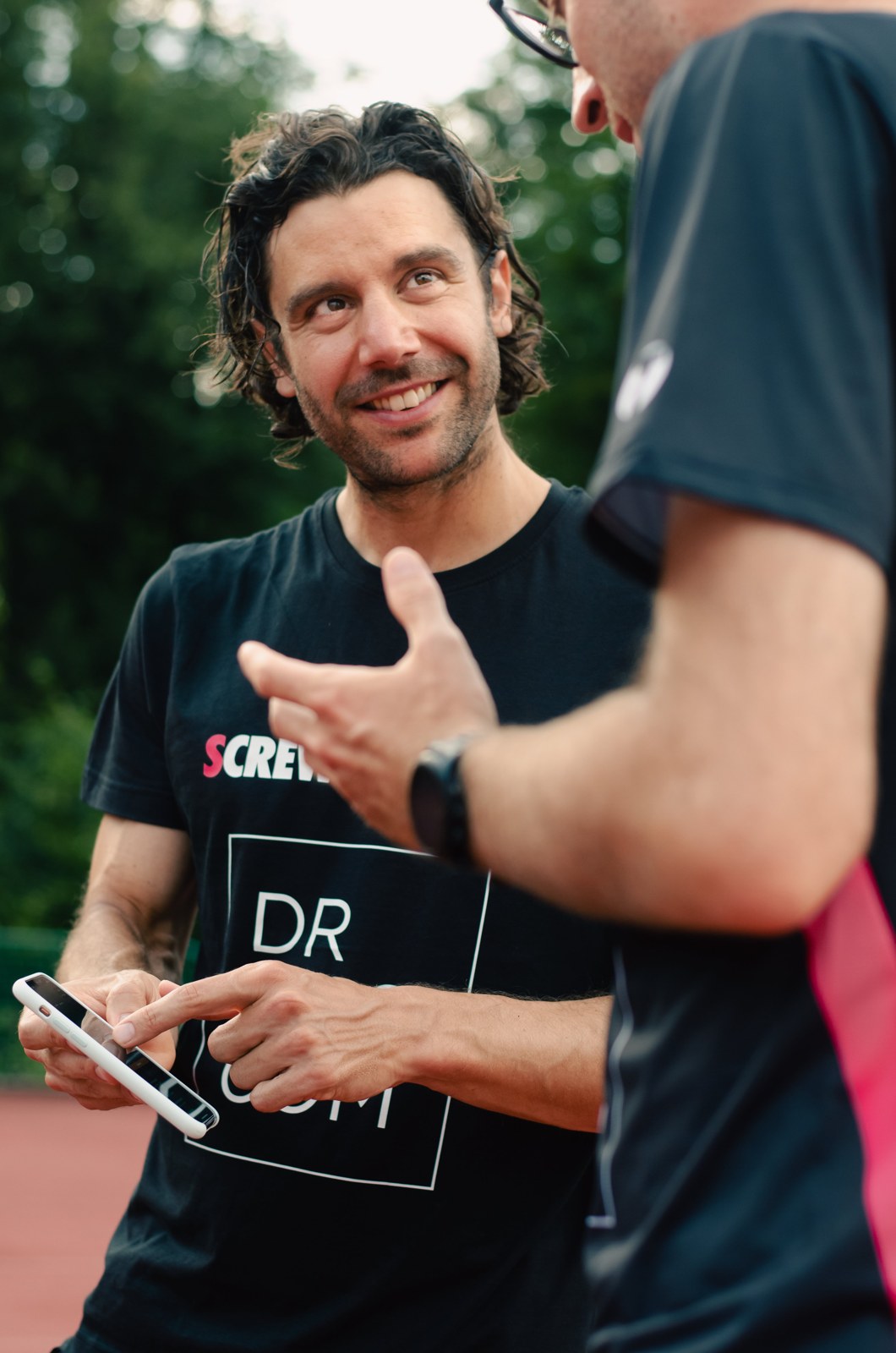 Pedro Dias in an outdoor conversation, holding a handheld device