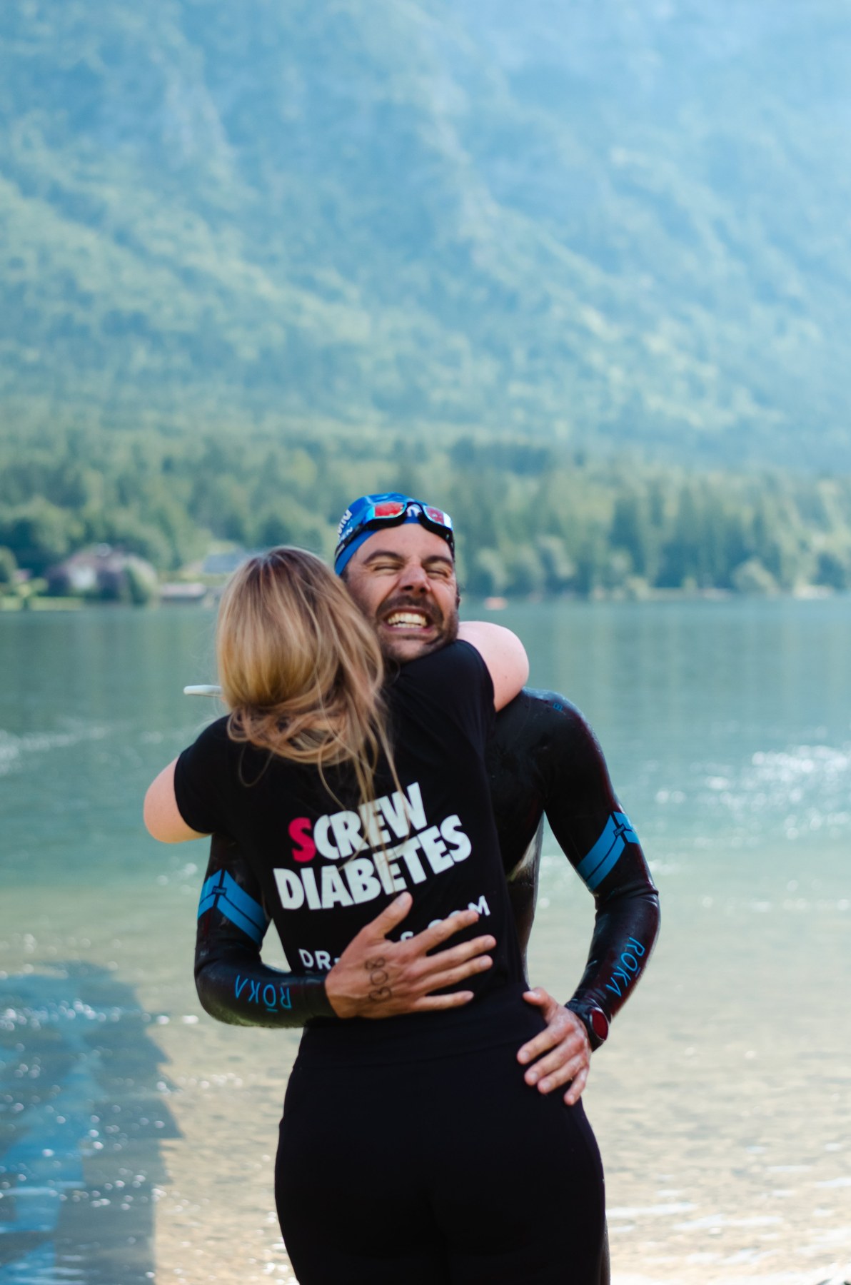 Pedro Dias embracing a supporter beside the lake after completing his 10 km swim