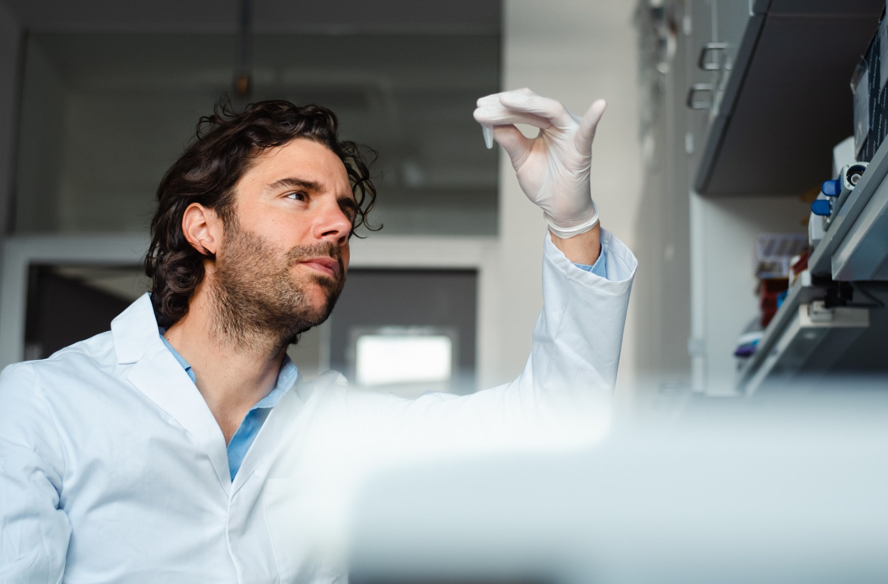 Pedro Dias examining a sample in a research laboratory